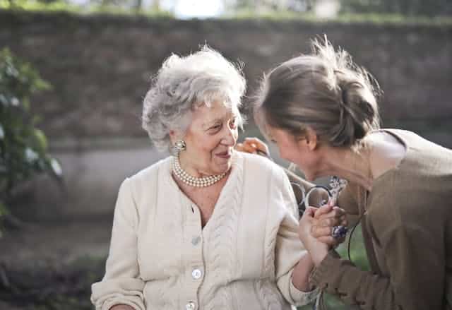 A woman is talking to an older woman who she cares for on a daily basis due to a medical condition and for which she receives a carer's allowance