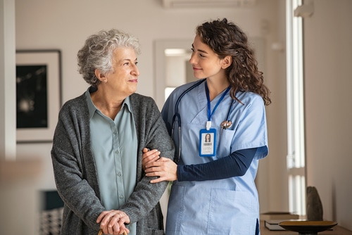 A healthcare worker supporting an elderly patient after the aged care royal commission.