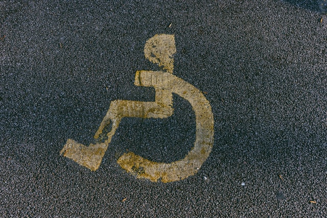 close up of yellow disability parking logo on tarmac