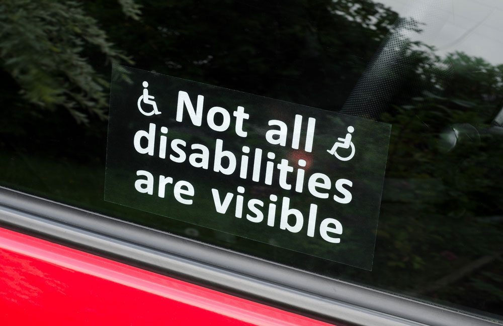 As with IDPwD, Australia's Disability Strategy promotes awareness, like this sign that reads "not all disabilities are visible" stuck on a window of a red car.