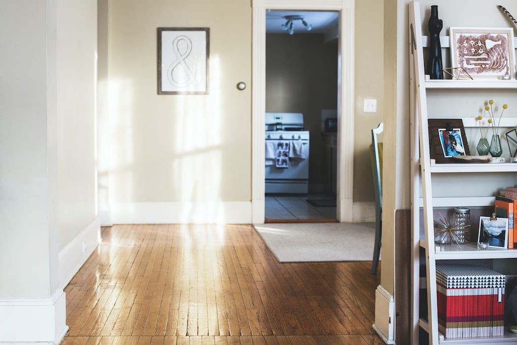 Stock photo of someone's home showing study and kitchen with buttercup yellow walls and wooden floors