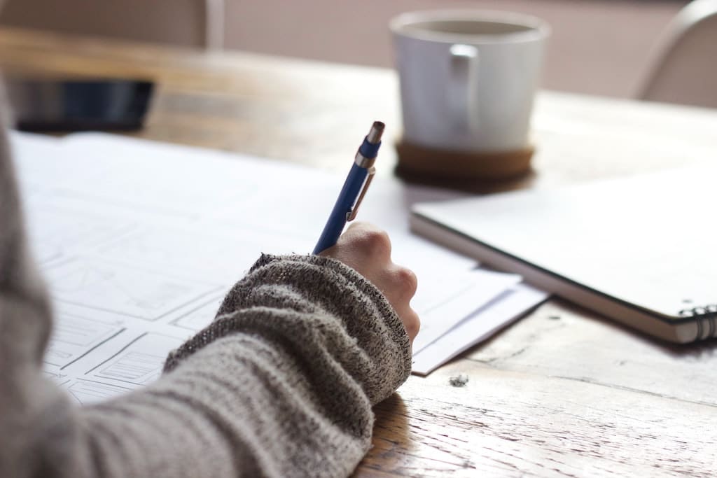 Close up of someone's hand drawing out a budget on a table - taking advantage of relevant disability discounts can help you save at tax time