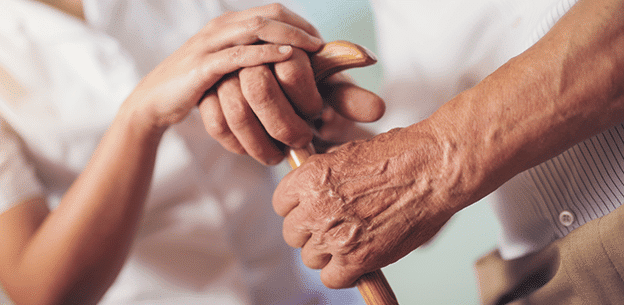 NDIS aupport worker holds persons hand