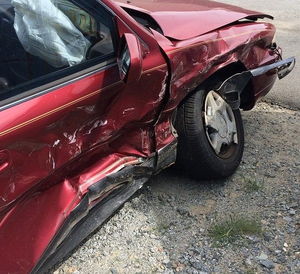 red car dented after a car accident and which will need an insurance claim