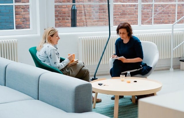 two women sitting at a table discussing NDIS plan review