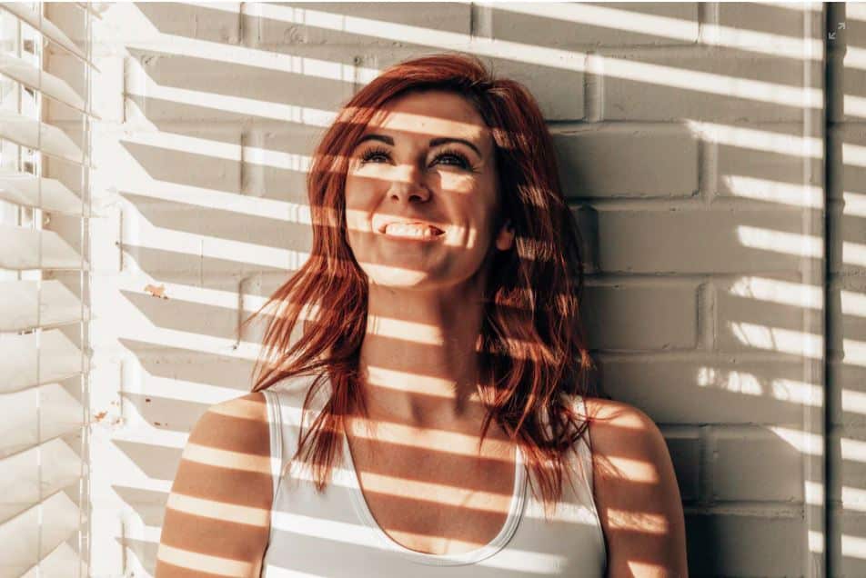 red haired woman looks into the light on Global Accessibility Awareness Day