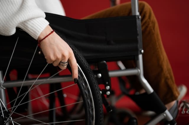 woman uses wheelchair with assistive technology to help reduce carpal tunnel syndrome
