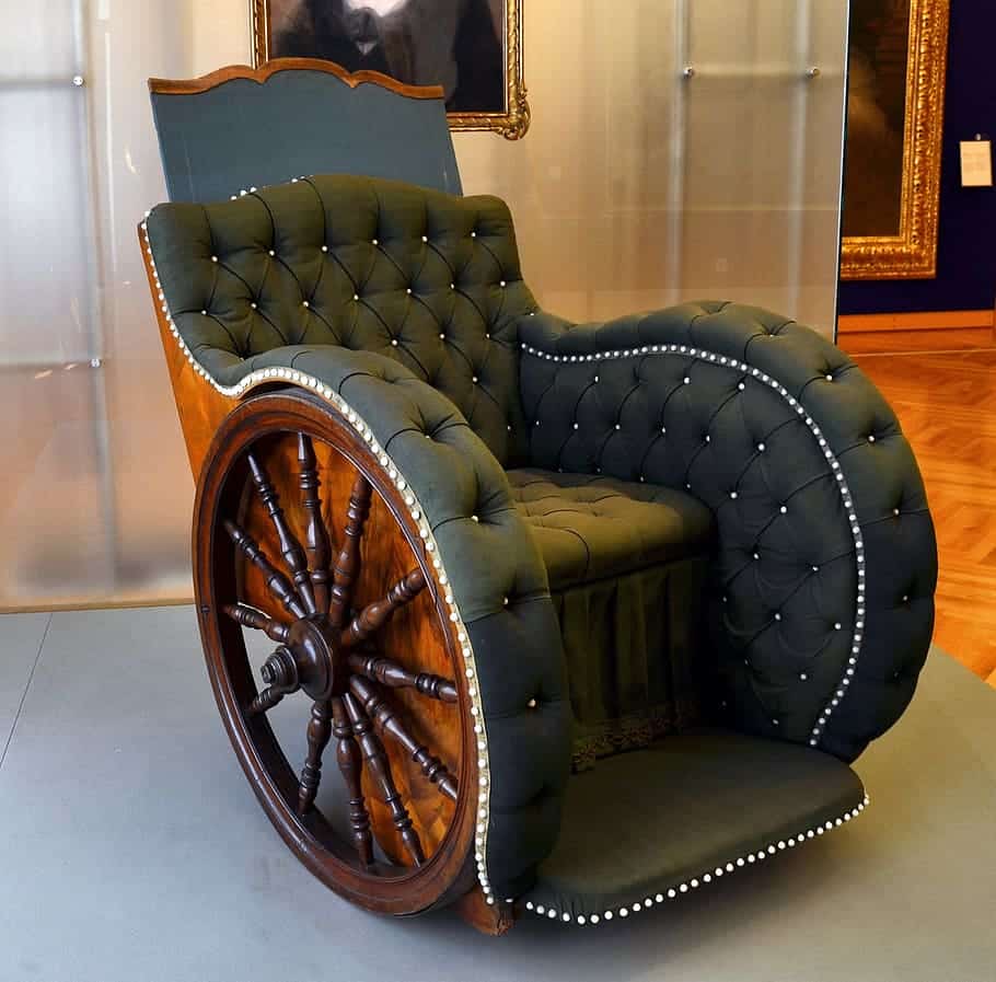 An early wheelchair, which like the first wheelchair is made of wood. 