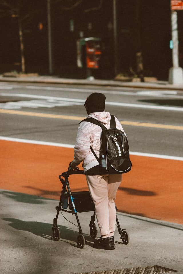 man using walker to get down street - someone with a temporary disability like an injury might be able to get a temporary disability parking permit