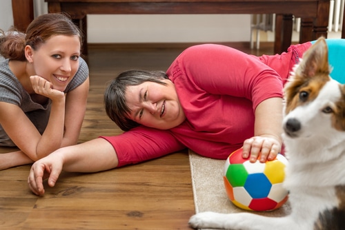 A carer and therapy dog working provide therapeutic support for this woman