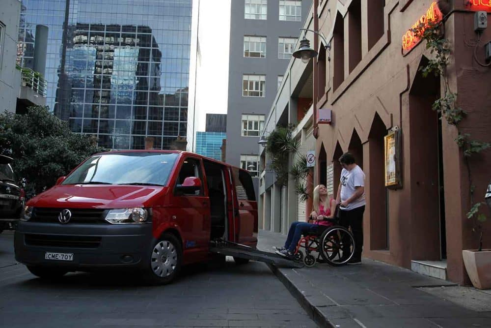 This 30s couple, the blonde lady in a wheelchair, are buying a Wheelchair Accessible Vehicle that's red