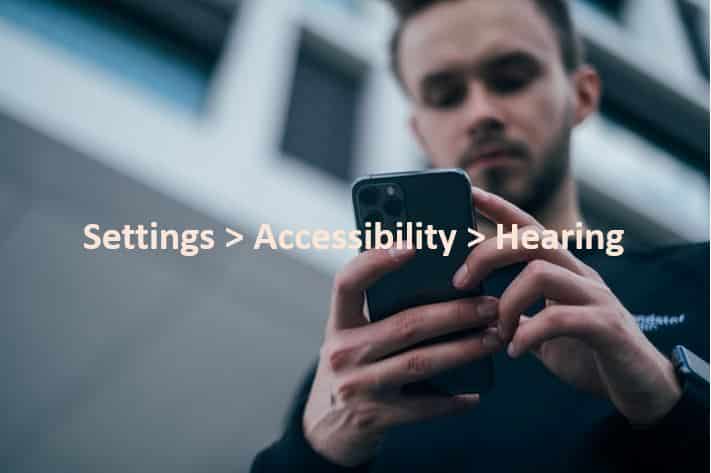 man changes hearing settings on his phone to use the accessible design functions