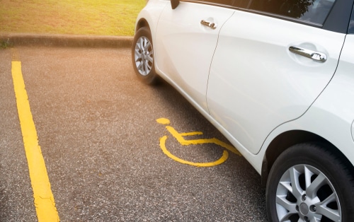 white car in disability parking spot 