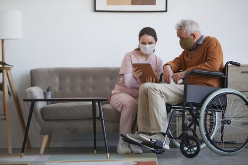 A carer and a man living with limited mobility look online to find out about the Independent Living Expo in Sydney and Brisbane program 