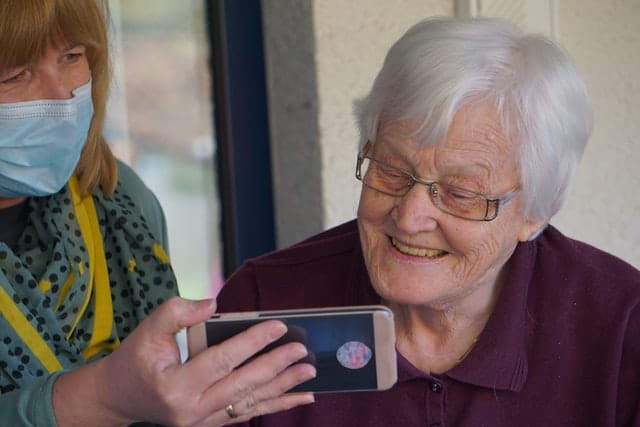 a support worker assists a senior Australian at home 