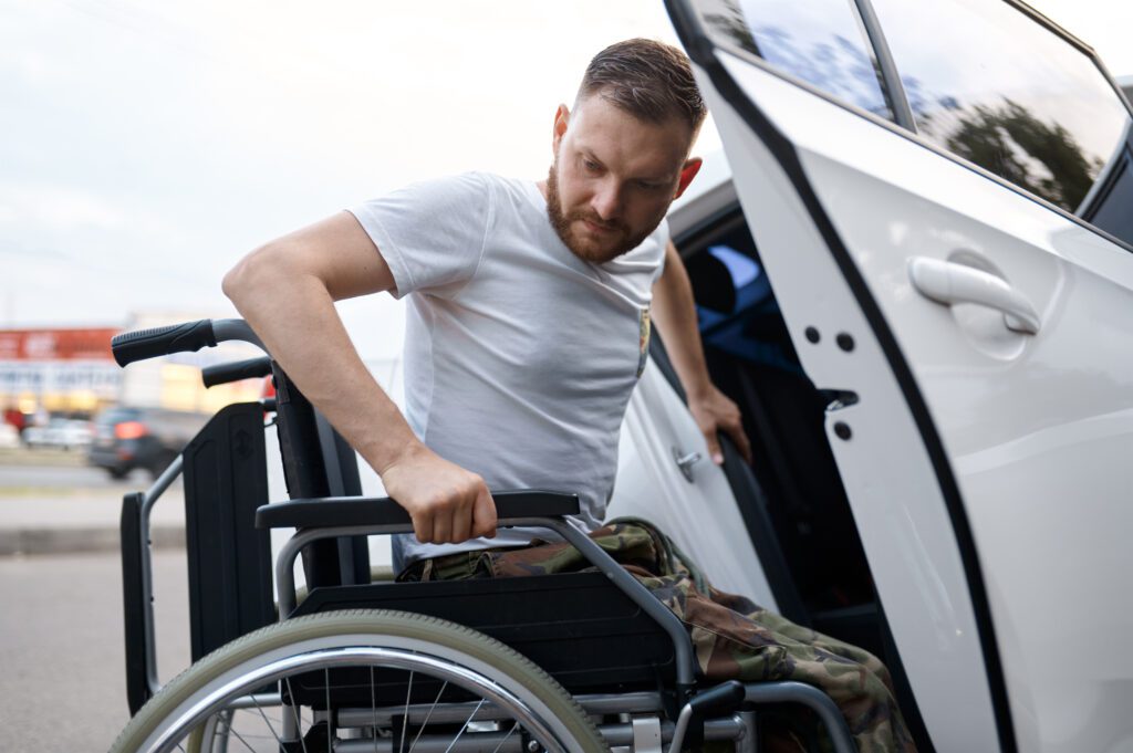 Retired veteran independently transfers from a car to a wheelchair. 
