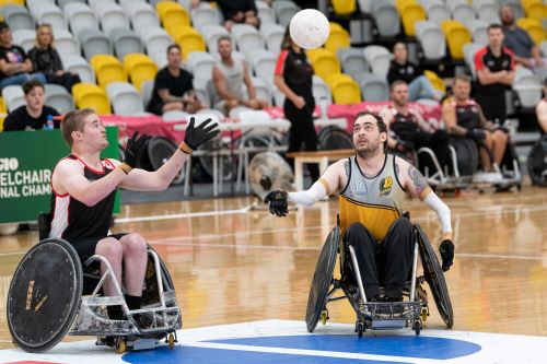 two wheelchair rugby players go for the ball