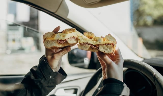 eating a burger like this at the wheel in Australia isn't illegal but can be when an incident happens