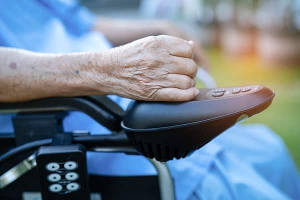 Elderly lady on electric wheelchair. This may be a front wheel drive power wheelchair