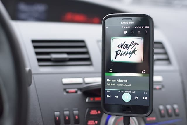 Keep music soft in the car and plan your playlist in advance, like this mobile phone owner has 
