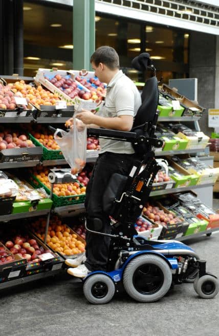 A man in a levo c3 stand up wheelchair doing shopping
