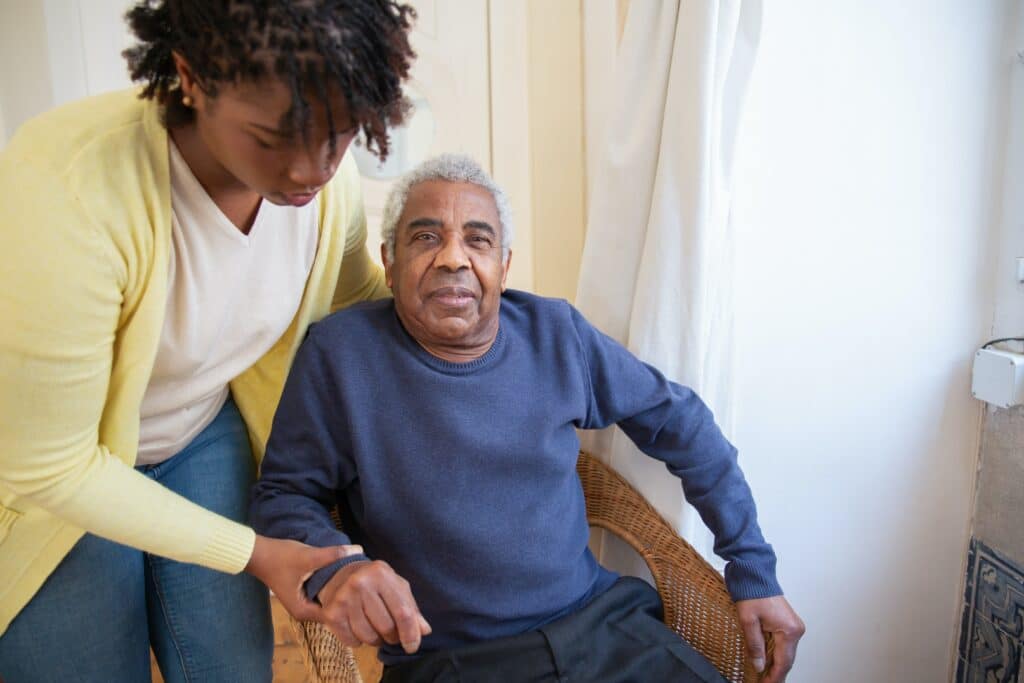 Travelling as a carer or support worker requires planning, something that’s understood by this lady wearing a yellow jersey helping an elderly man wearing a blue sweater.