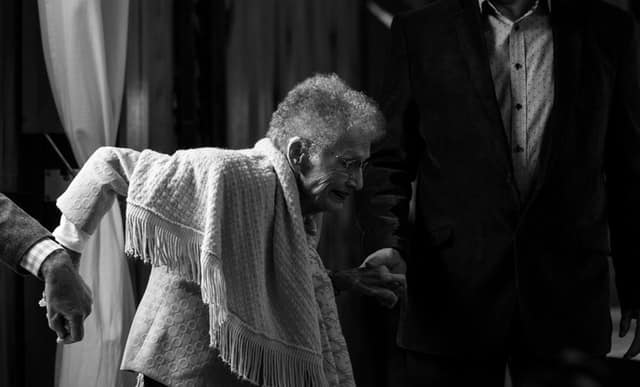 Dementia symptoms, as with Alzheimer's, can eventually include reduced mobility, like in this black and white photo of a frail lady trying to get up