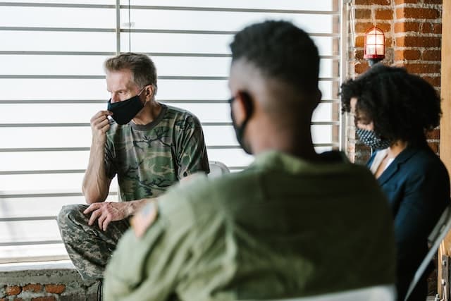 military men debrief with a psychiatrist who explains what PTSD is to help them cope