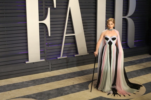 Actress Selma Blair in a pink and black dress stands in front of a Vanity Fair sign, advocating for disability visibility