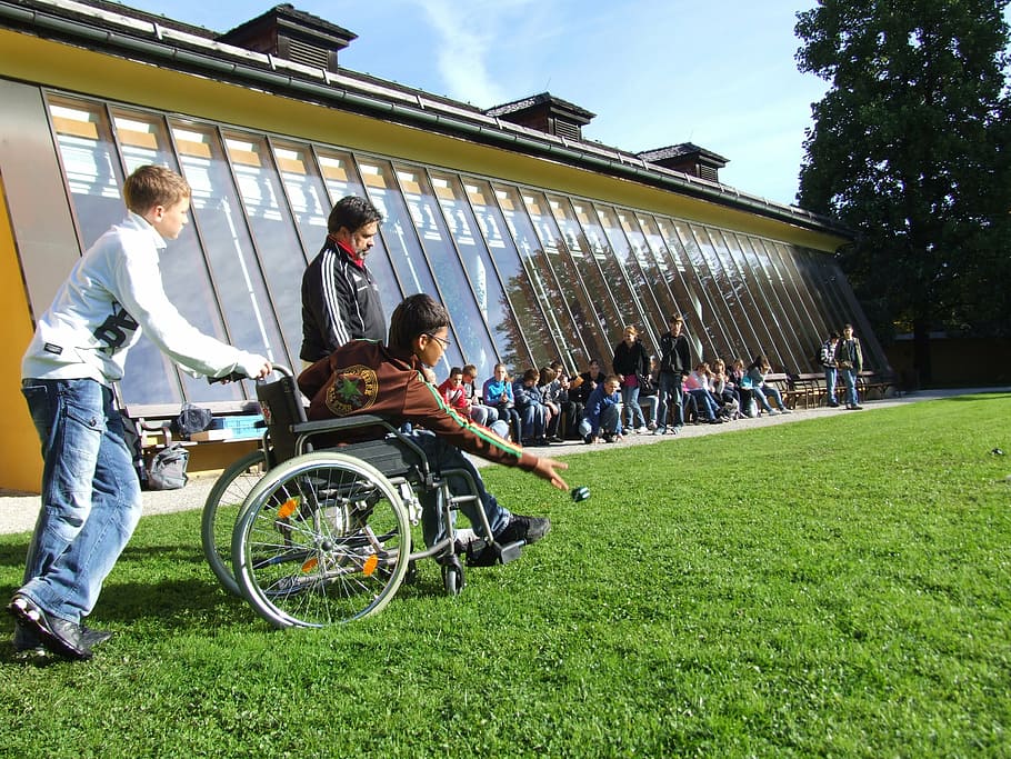 A boy in a wheelchair plays with his friends at school