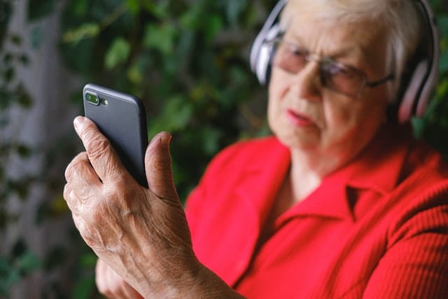 a woman with low vision and hearing abilities uses her smartphone accessibility features like screen reader, to enhance her daily activities