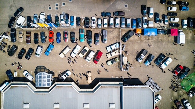 High-angle photo of parked vehicles beside a building.