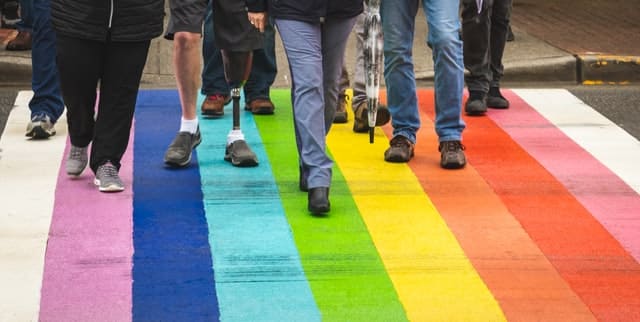 a man with disability crosses a colourfully painted road representing diversity and inclusion in art in Australia