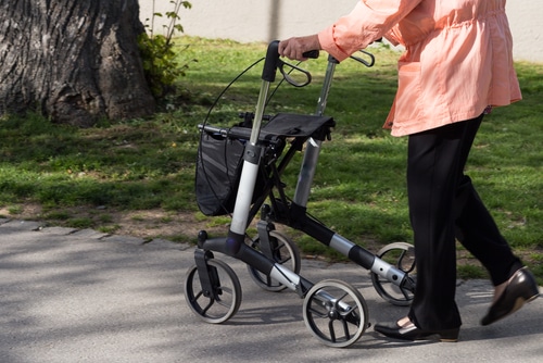 A senior lady walks with a rollator in park in south Germany. Mobility aids provide independence and confidence.