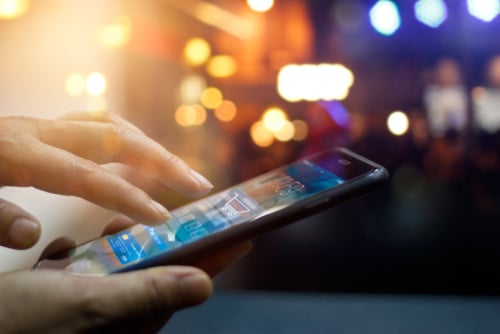 This image shows a man's hand using an app on a phone