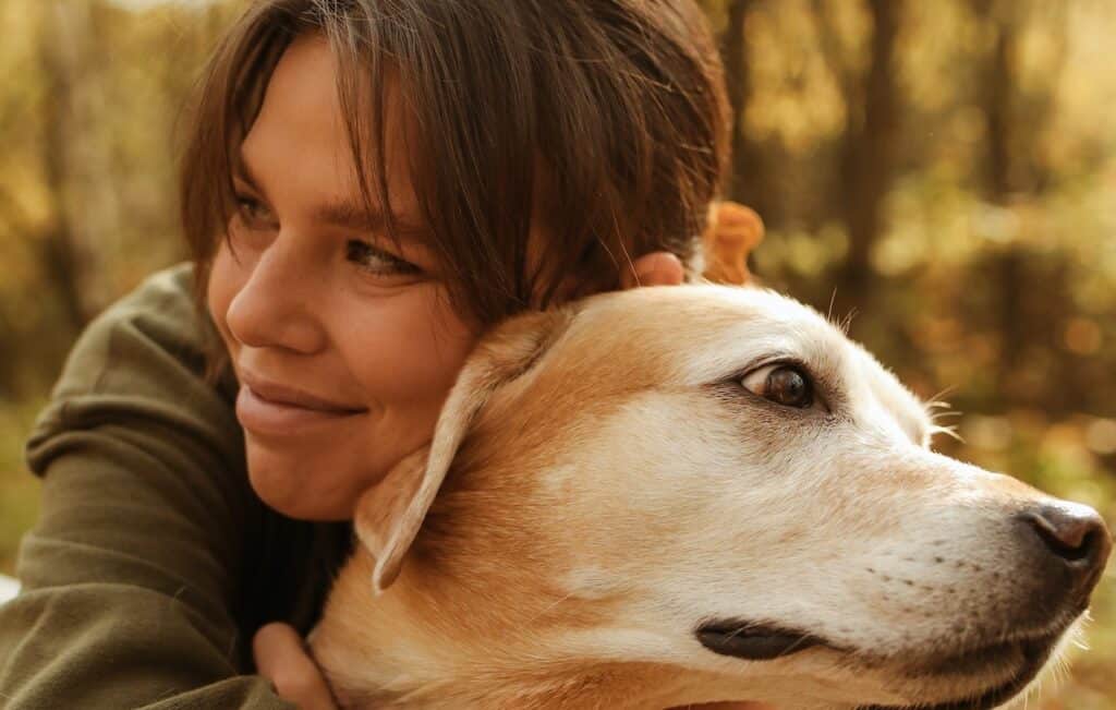 A woman hugs her assistance dog who has third party liability Assistance Dog insurance