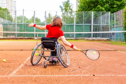 An Australian woman plays wheelchair tennis, an inclusive disability sport