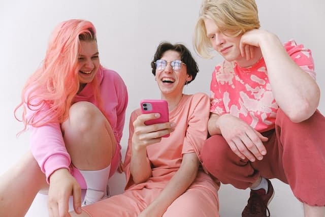 girl uses assistive technology on her smartphone to describe the colours of her friends' clothes