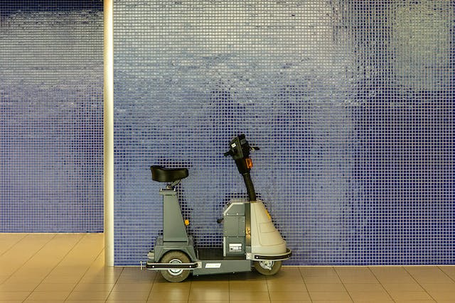 A scooter leaning against a wall, implying mobility support.