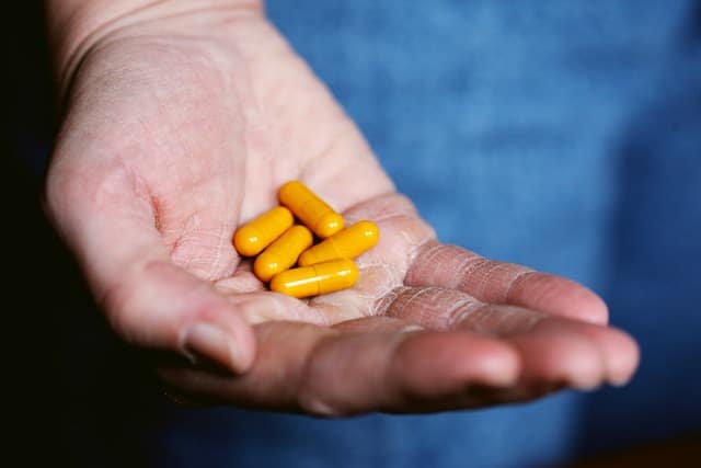 An image of a hand with capsule in it. This man is taking medication for diabetes type 1 or diabetes type 2