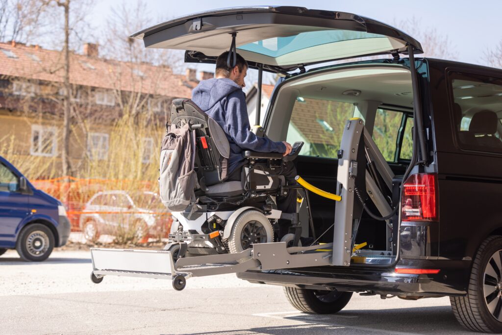 a man in a wheelchair gets lifted into a wheelchair accessible vehicle
