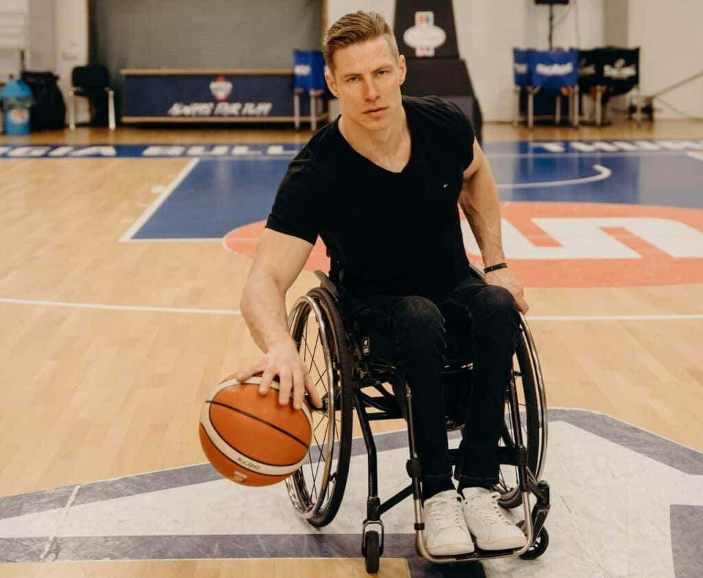 A man gets warmed up to play basketball, an inclusive sport that can be played by people with paraplegia