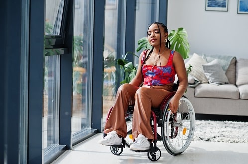 This is an image of a woman in her wheelchair enjoying the view at a wheelchair accessible accomodation in Australia.