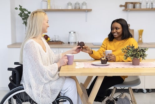 This is an image of two friends enjoying a cup of coffee at a wheelchair accessible resort in Australia. 