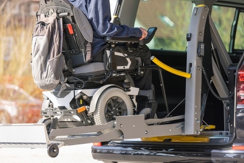A man uses a wheelchair lift to easily access his vehicle during a wheelchair accessible vehicle road trip