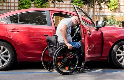 a man with a wheelchair drives his modified car with peace of mind knowing it's protected by discounted disability car insurance