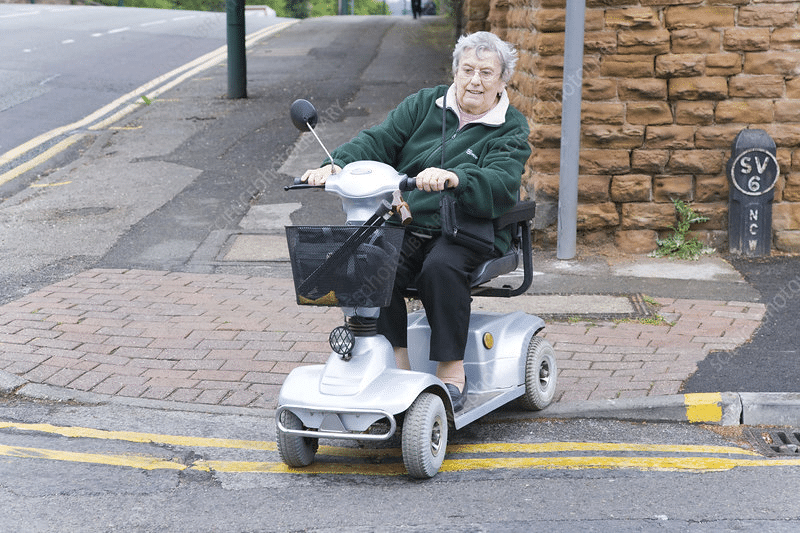 A woman with a disability parking permit is riding a motorized scooter on a street, thankful for her car insurance discount