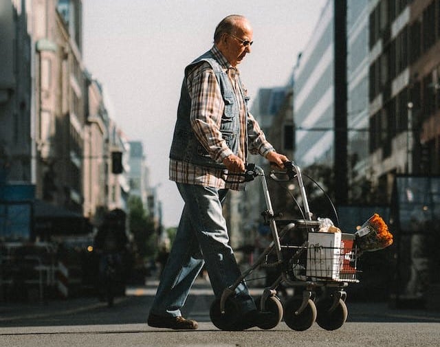 An Australian senior walking down the street with a walker supplied by the CHSP service.