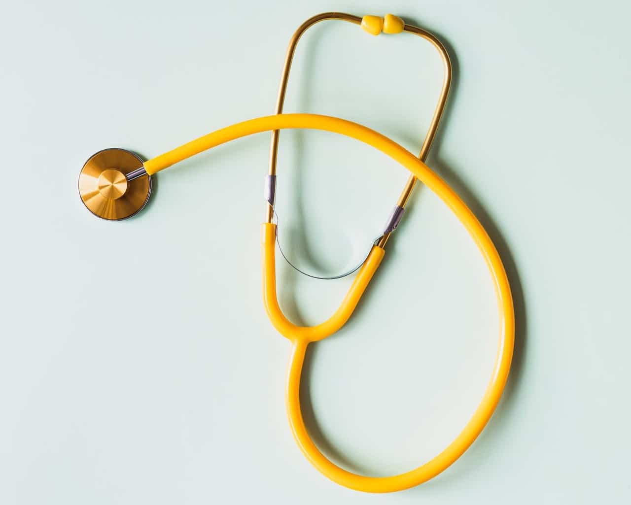 A yellow stethoscope on a light background, highlighting essential medical equipment.