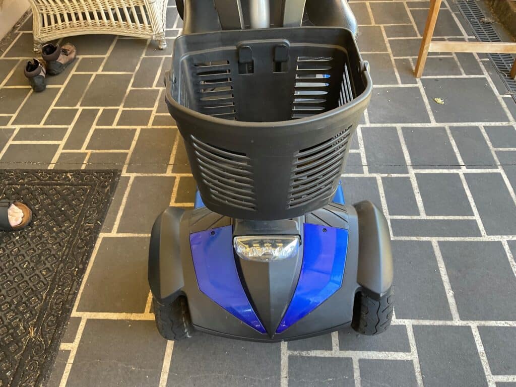 A blue and black scooter with a basket on it, suitable for mobility scooter parts.
